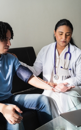 Doctor performing a general health checkup by monitoring blood pressure and pulse at Doctor Gowri's Balaji Hospital.